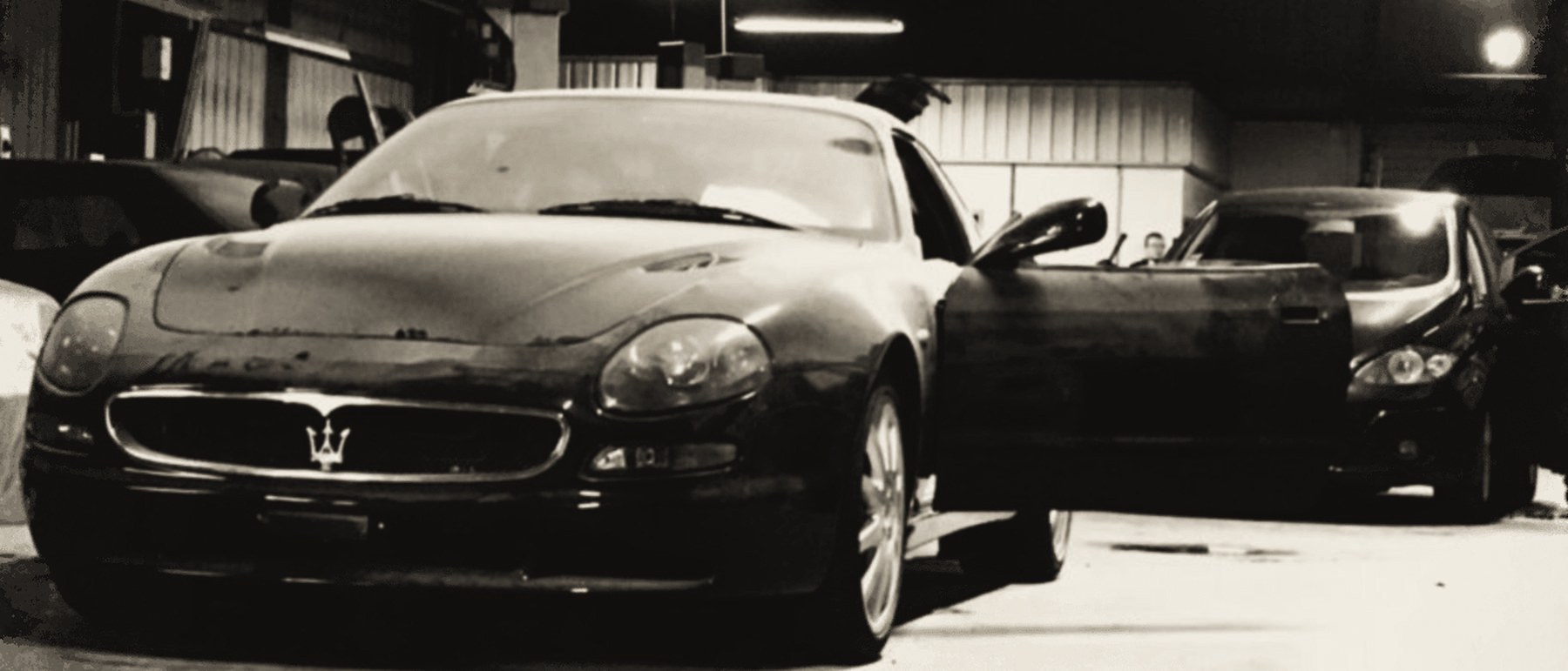 Un coupé de sport à l'atelier, portière ouverte.