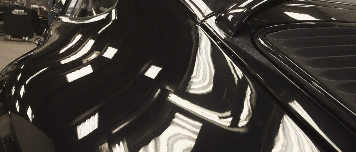 Reflets des néons de l'atelier dans une laque noire.